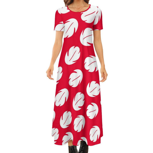 A woman wearing a red dress with white leaf patterns.