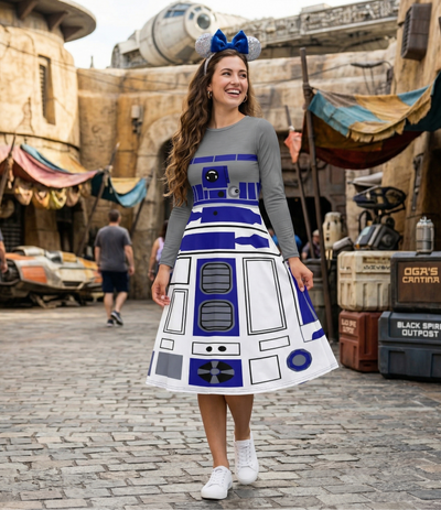 Person wearing a Star Wars-themed R2-D2 dress in a themed area with props and decorations.