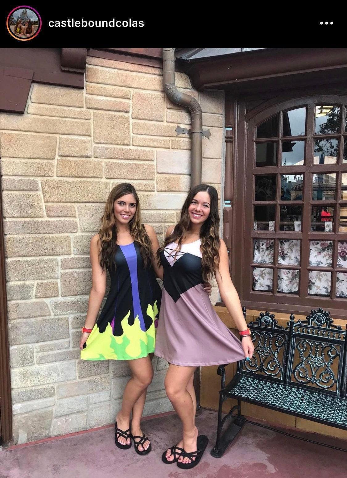May include: A sleeveless black dress with a purple vertical stripe and a lime green flame pattern at the hem, alongside a sleeveless dress with a white bodice, black crisscross neckline, and a mauve skirt, both featuring a flared silhouette.